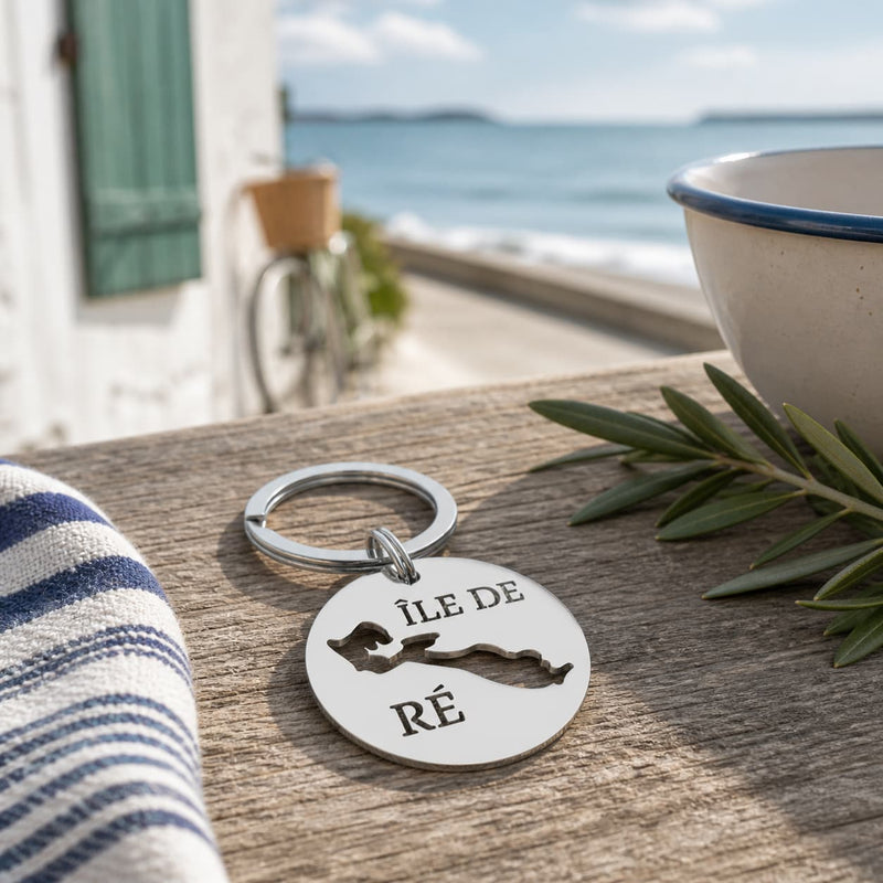 Porte-clé Île de Ré en inox posé sur table en bois ambiance bord de mer